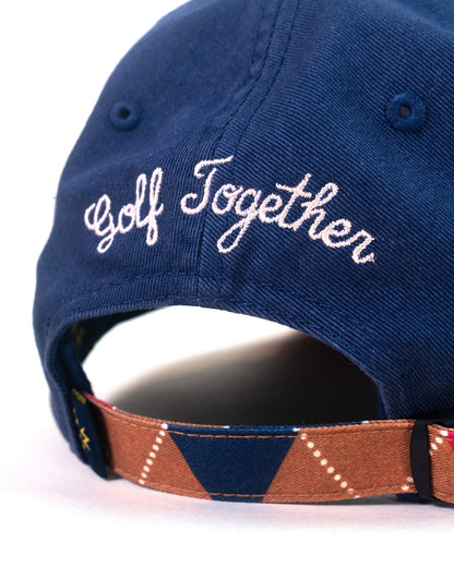 Back of a navy dad cap with embroidered white Golf Together text and an argyle strap back.