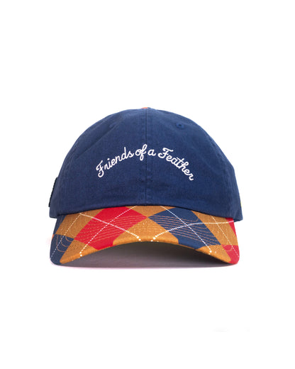 Front of a navy six-panel cap with white cursive text embroidery and a red, yellow, and blue argyle brim.