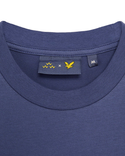 Detail of a crown blue t-shirt with inner neck tags showing brand logos and the size M label.