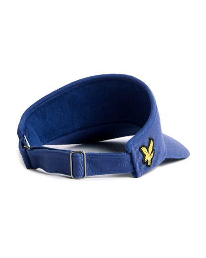 Back of a navy cotton twill visor featuring an adjustable metal strap, inner terry headband, and yellow eagle logo.
