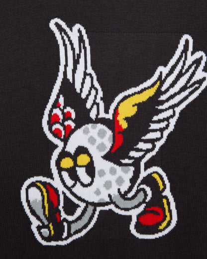 Detail of a black sweater featuring a white winged golf ball graphic with red and yellow wing details.