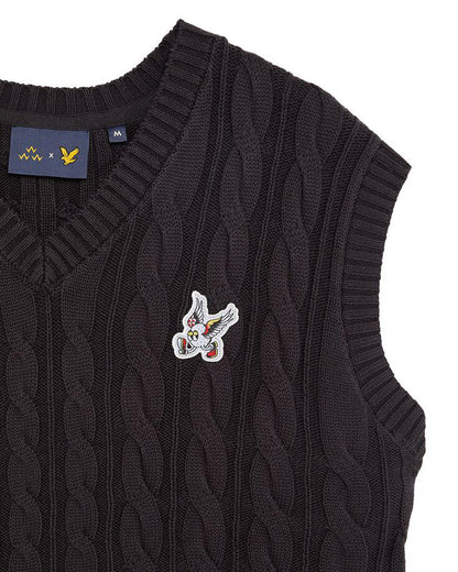 Detail of a black cable knit vest featuring a winged golf ball embroidered badge.