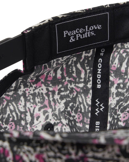 Detail of the inside of a black motley cap showing a pink and white print lining and inner text labels.