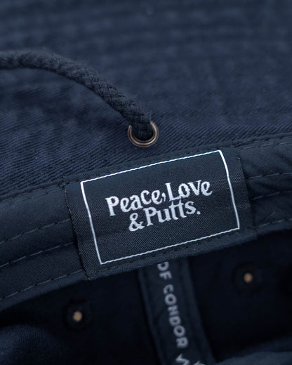 Detail of the navy cotton boonie hat interior showing a logo tag that reads Peace, Love & Putts.
