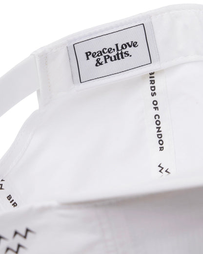 Detail of the inside of a white nylon cap with a woven logo patch reading Peace Love and Putts.