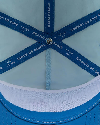 Detail of sky blue cap interior showing blue seam taping printed with white text.