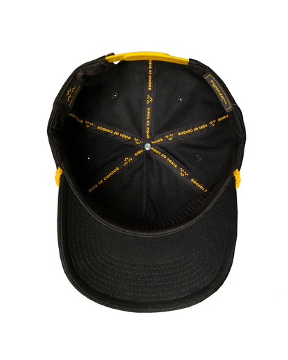 Detail of the inside of a black cap with yellow printed internal taping and a yellow snapback closure.