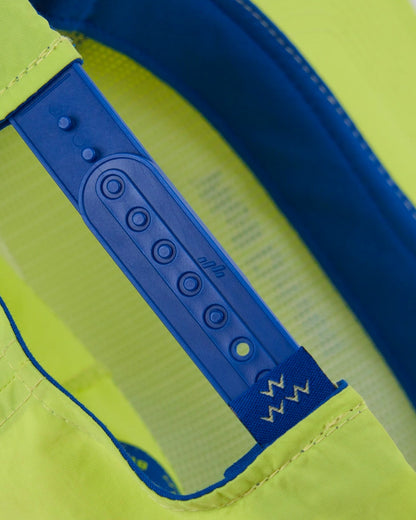 Detail of a lime snapback hat featuring an adjustable blue plastic back strap.
