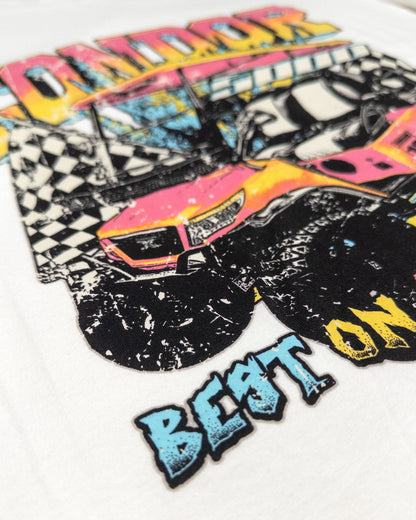 Detail of a white t-shirt with a retro print featuring a pink race car and text.