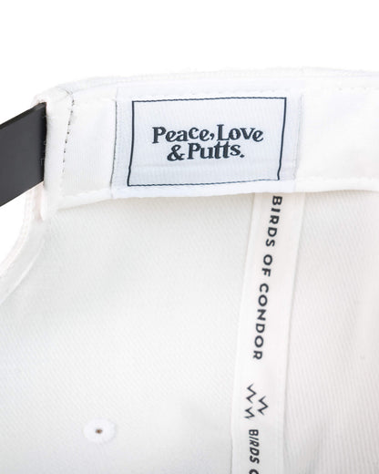 Detail of the white snapback interior showing a woven label reading Peace, Love & Putts.