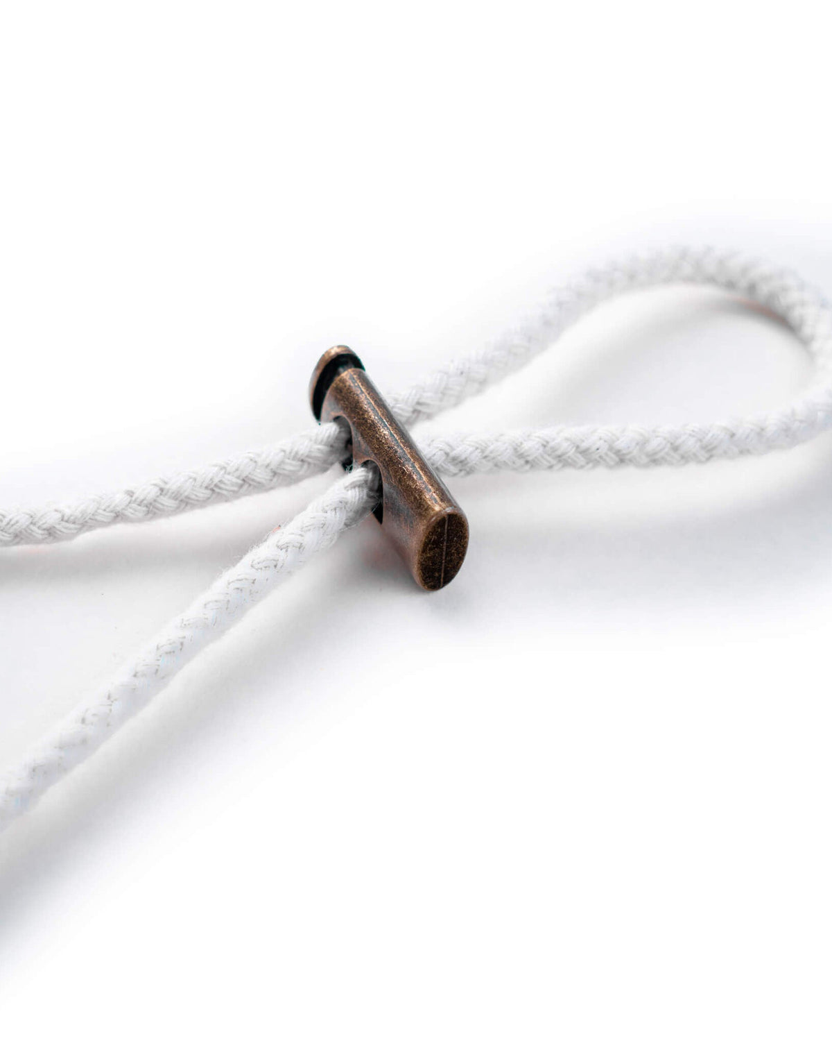 Detail of the white cotton boonie hat drawcord fastened with a brass toggle.