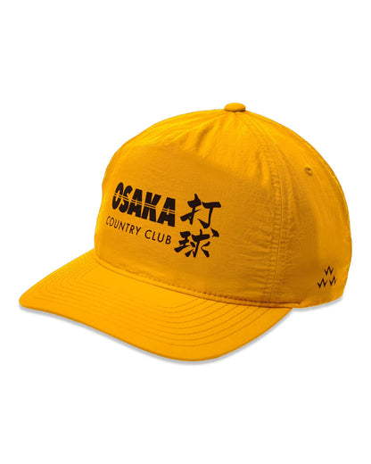 Yellow 5-panel snapback cap featuring a black OSAKA COUNTRY CLUB graphic and kanji design on the front.