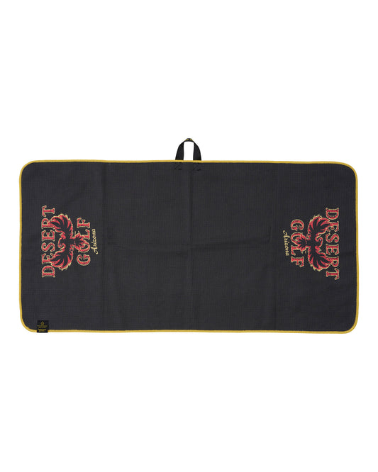 A black rectangular golf towel with a yellow border, featuring the 'Desert Golf' logo printed in red and gold on both sides. 